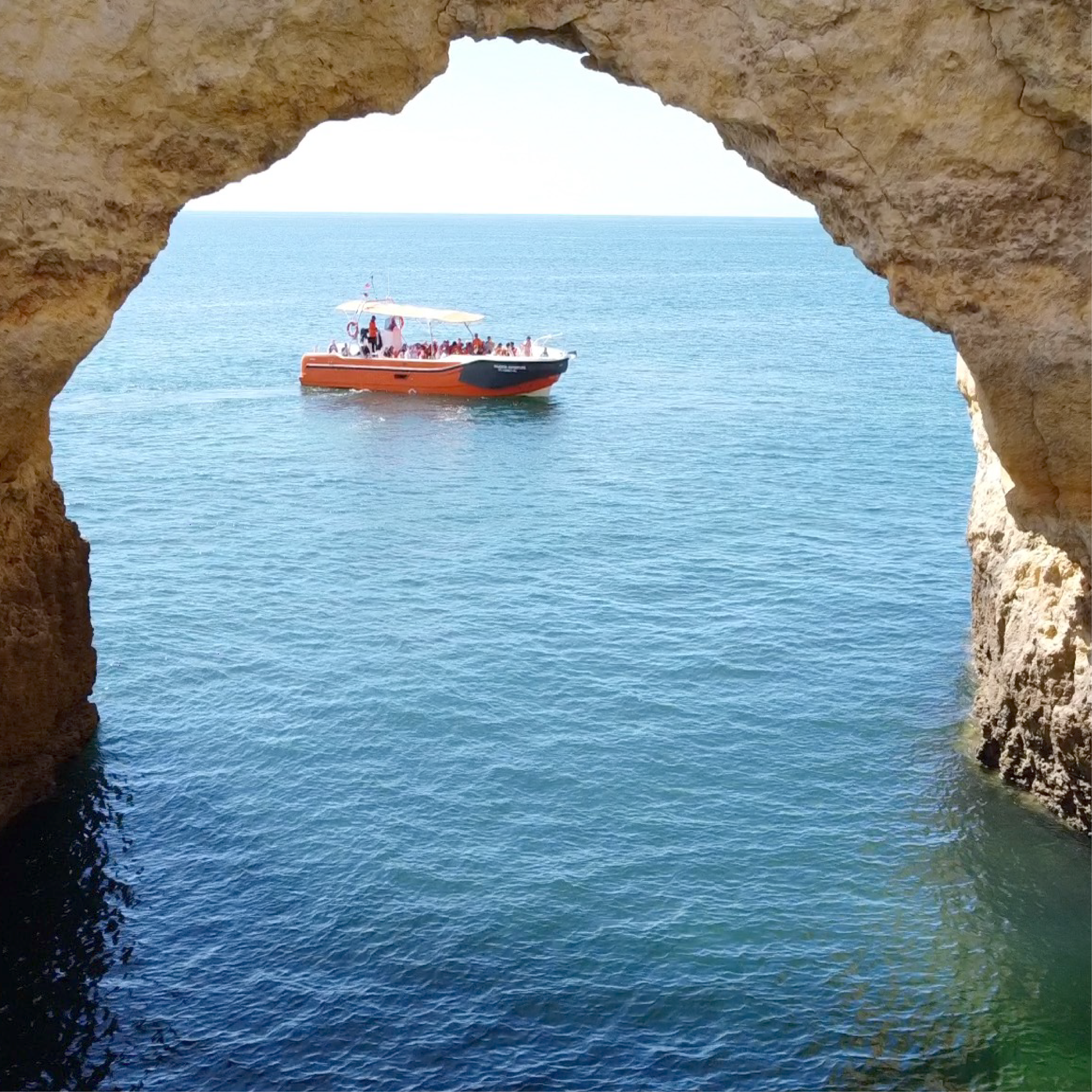 Boat approaching Benagil Cave during a scenic boat tour along the Algarve coastline in Portugal